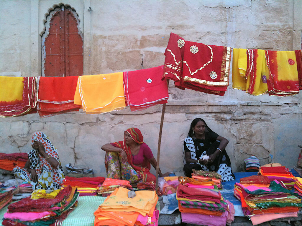 Fabric Ladies Jodhpur Market sitting amongst colorful traditional Indian fabric and clothing