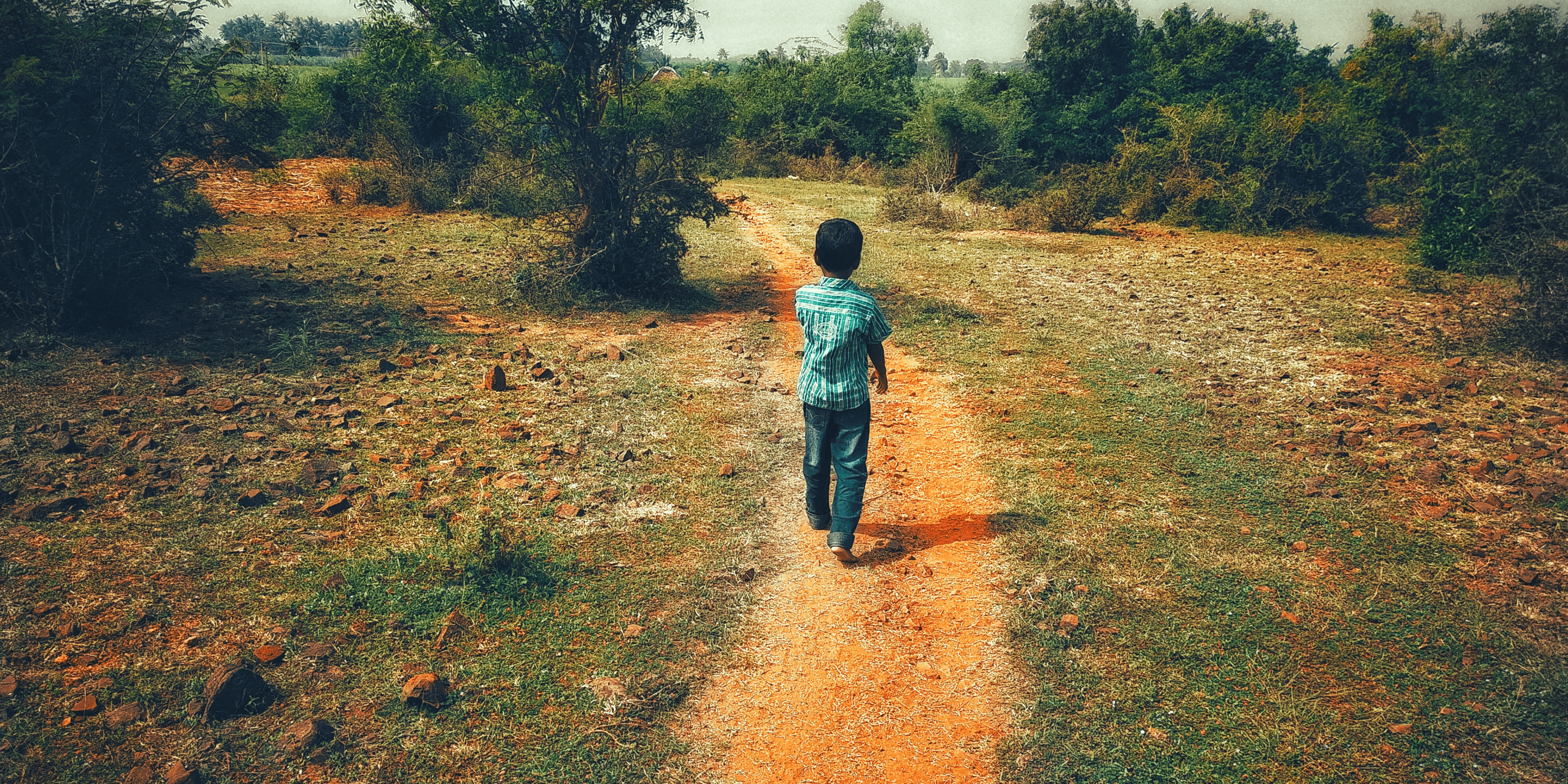 Child walking down dirt path